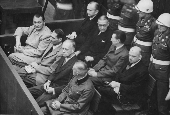 Imagen de la bancada de acusados en el Proceso principal de Núremberg. Delante, de izquierda a derecha: Hermann Goering, Rudolf Hess, Joachim von Ribbentrop, Wilhelm Keitel. Detrás, de izquierda a derecha: Karl Doenitz, Erich Raeder, Baldur von Schirach y Fritz Sauckel (Dominio público)