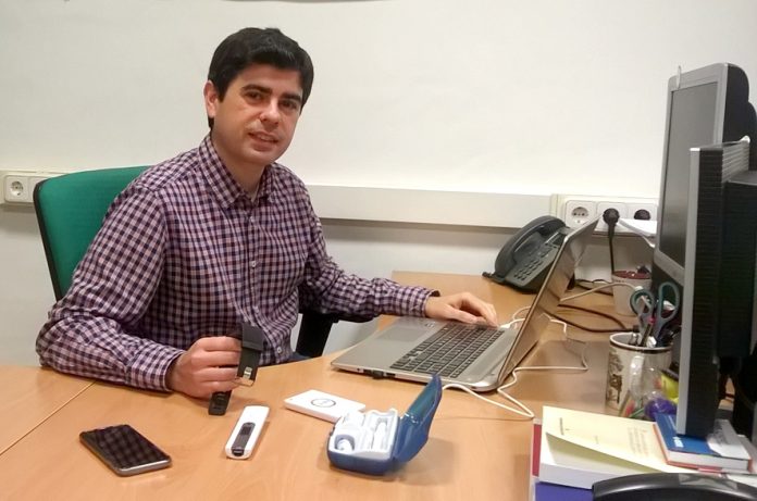 El investigador del grupo MAmI Jesús Fontecha Diezma sostiene un dispositivo que facilita el seguimiento, en este caso, un reloj